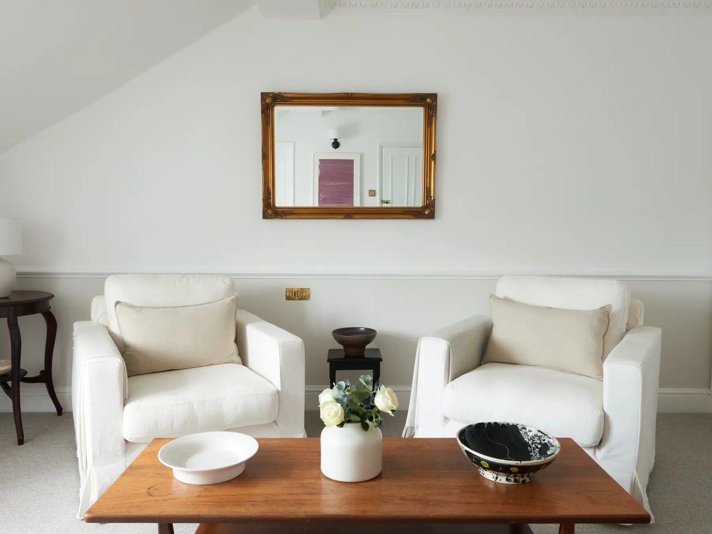 Room 1 — two armchairs below a gilt-framed mirror